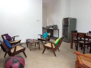 um quarto com cadeiras e mesas e um frigorífico em Ridmi Home Stay em Karagampitiya
