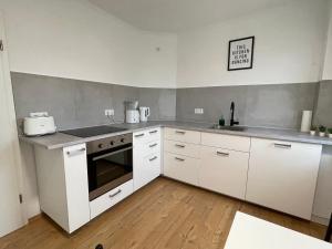 a kitchen with white cabinets and a stove top oven at Modern 4 Zi Rooms Netflix, Wifi, Parken CasaLuna85 in Flöha