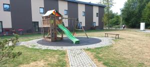 um parque infantil com escorrega e escorrega em Grafu Lankos Vėžių g 26 K5-12 em Palanga