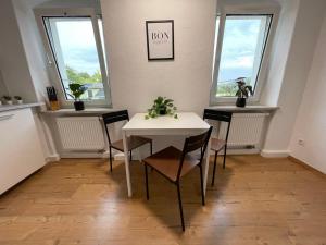 - une salle à manger avec une table, des chaises et des fenêtres dans l'établissement Modern 4 Zi Rooms Netflix, Wifi, Parken CasaLuna85, à Flöha