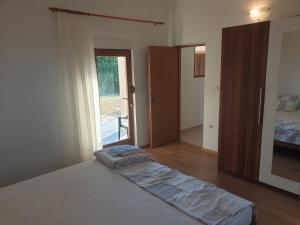 een slaapkamer met een bed en een glazen schuifdeur bij Impeccable 2-Bed House in Privlaka Croatia in Privlaka