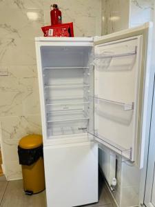 einen weißen Kühlschrank mit offener Tür in der Küche in der Unterkunft Superb and Comfortable 3BD Home in Dagenham in Dagenham
