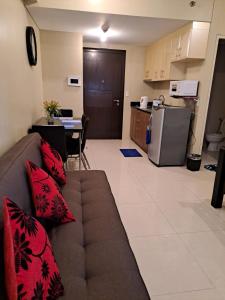 een woonkamer met een bank en een keuken bij MRMcondotel in Manilla