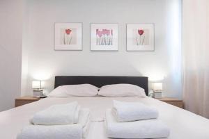 1 dormitorio con 1 cama blanca y 2 almohadas en Cozy Studio, Athens city center, en Atenas