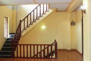 a staircase in a building with a wooden railing at Spice & Herb Rooms & Food in Kandy