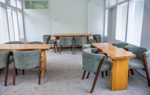 eine Reihe von Tischen und Stühlen in einem Zimmer mit Fenstern in der Unterkunft Hotel Reego in Skardu