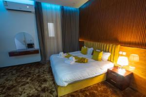 a bedroom with a large bed with yellow pillows at فندق ابيات الشمال in Rafha