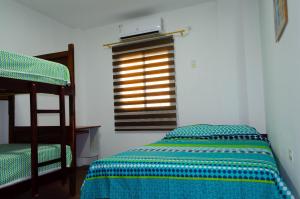 a bedroom with a bunk bed and a window at La Posada de Joselito in Crucita