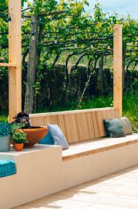 un banco de madera con algunas plantas. en Just Like Home - Casa Antonio em Paredes de Coura, en Paredes de Coura