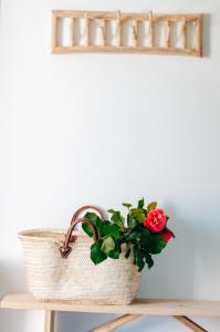 un panier avec une fleur rouge sur une table dans l'établissement Just Like Home - Casa Antonio em Paredes de Coura, à Paredes de Coura
