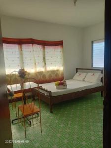una camera con un letto e una sedia di WJV INN LILOAN a Liloan