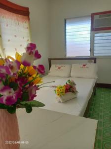 una camera da letto con un letto fiorito di WJV INN LILOAN a Liloan