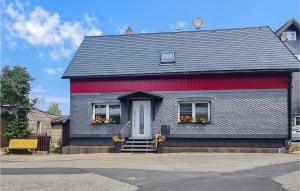 une maison grise et rouge avec des fleurs dans la fenêtre dans l'établissement Stunning Home In Neuhaus A,r, Ot Steinh With Kitchen, à Steinheid