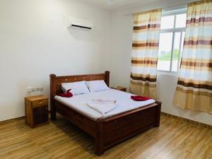 a bedroom with a bed with white sheets and a window at villa liam kiwengwa zanzibar in Kiwengwa