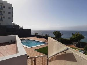 een uitzicht op een zwembad en de oceaan vanuit een gebouw bij LALUNA2 in Bajamar
