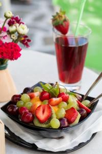 um prato de fruta numa mesa com uma bebida em Arco Naxos Luxury Apartments em Naxos Chora