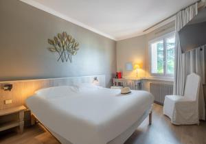 A bed or beds in a room at Hôtel Causse Comtal Rodez, The Originals Relais