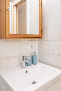 een badkamer met een witte wastafel en een spiegel bij Palamì - Polignano a Mare Holiday House in Polignano a Mare