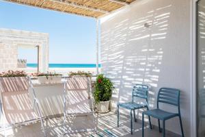 patio z krzesłami i stołem oraz widokiem na ocean w obiekcie Palamì - Polignano a Mare Holiday House w mieście Polignano a Mare