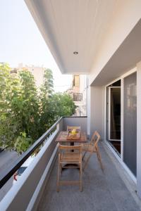 un piccolo balcone con tavolo e sedie in legno di Chania Central Apartment a Chania