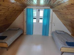 two beds in a small room with blue curtains at Cosy Holiday Home with sauna for family vacation 
