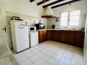 uma cozinha com um frigorífico branco e um lavatório em Maison Espelette, 4 pièces, 5 personnes - FR-1-495-2 em Espelette
