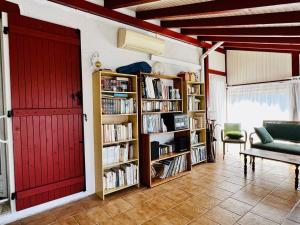 uma sala de estar com uma porta vermelha e prateleiras de livros em Maison Espelette, 4 pièces, 5 personnes - FR-1-495-2 em Espelette