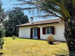 una pequeña casa blanca con chimenea y palmera en Maison Espelette, 4 pièces, 5 personnes - FR-1-495-2 en Espelette