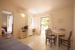 a room with a table and chairs and a kitchen at Residence Villa Morcone in Capoliveri