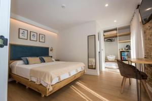 a bedroom with a bed and a table and a desk at O Relax do Río - Casa Molino Boutique, con Jardín y Desayuno en Muxía in Muxia