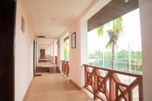 a corridor of a building with a balcony with a palm tree at Greenleaf The Resort & Spa, Ganpatipule in Ganpatipule