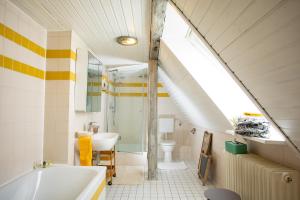 an attic bathroom with a sink and a tub and a sink at Ferienwohnung am Schlossgarten in Schmieheim +13 photos
