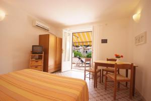 een slaapkamer met een bed, een bureau en een tafel bij Residence Villa Morcone in Capoliveri