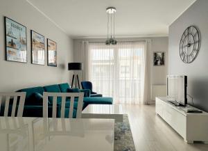 a living room with a blue couch and a tv at Przestronne Studio Blisko Morza in Gdańsk