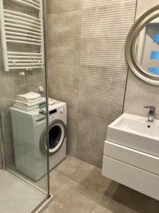 a bathroom with a washing machine and a sink at Przestronne Studio Blisko Morza in Gdańsk