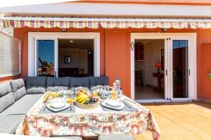 a table with a bowl of fruit on top of a patio at Fantastic View & Terrace Apt by Dream Homes Tenerife in Puerto de Santiago