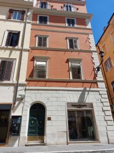 un edificio alto con una puerta verde en una calle en Rock n Rome - Piazza di Spagna - Via del Babuino, en Roma
