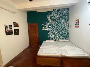 瓦尔卡拉Hope Hostels, Varkala - Helipad的一间设有两张床和绿色墙壁的客房
