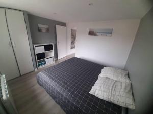 Bel Appartement T2 40 M2 في Vaugneray: غرفة نوم صغيرة مع سرير في غرفة