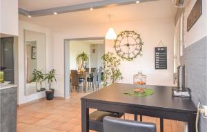 une cuisine et une salle à manger avec une table et une horloge dans l'établissement Nice Home In St,paul-trois-chteaux With Kitchen, à Saint-Paul-Trois-Châteaux
