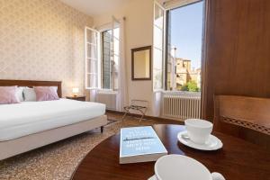 a bedroom with a bed and a table with a book at Residenza Centopietre - Dorsoduro in Venice