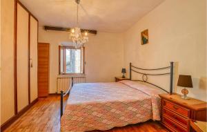 1 dormitorio con cama y lámpara de araña en Gorgeous Home In Gallicano Fraz, Bologn With Wifi, en Bolognana