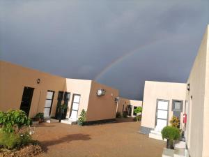 un arco iris en el cielo sobre un grupo de edificios en Royal guesthouse en Opuwo