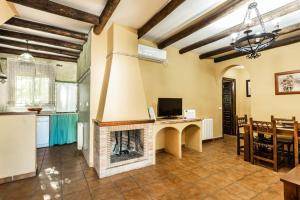 a kitchen and a living room with a fireplace at Complejo turistico El Álamo in Hornachuelos