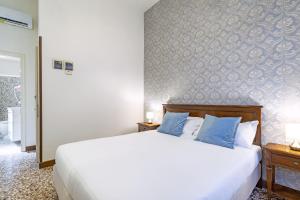 a bedroom with a large white bed with blue pillows at Residenza Centopietre - Dorsoduro in Venice