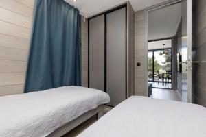 a bedroom with two beds and a window at Living Point Mobile Homes in Mali Lošinj