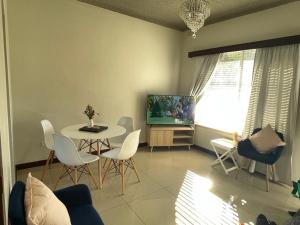 a living room with a table and chairs and a tv at Beach Retreat in Henley Beach South