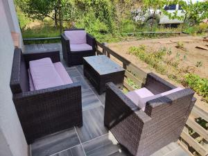 a patio with wicker furniture and a table and chairs at La maisonnette du jardin Narbonne in Narbonne