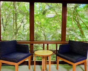two chairs and a table in front of a window at Tsukihitei in Nara