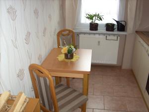 a small kitchen with a wooden table and chairs at Ferienwohnung Bauer in Thale
